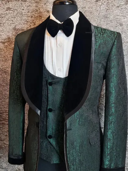 A green jacquard tuxedo with a black velvet lapel. The texture of the fabric gives it a very rich and luxurious appearance.