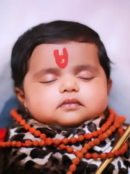 An extreme close-up on the baby's face in the 'Little Shiva' theme, capturing the peacefulness and innocence.