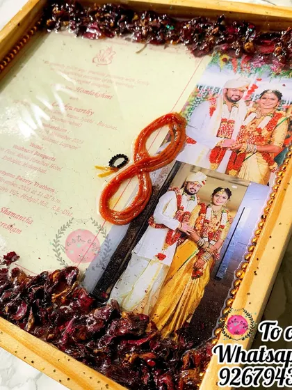 This frame from a South Indian wedding preserves the wedding card, photos, and the sacred thali rope (mangalsutra). It's a beautiful way to honor wedding traditions.