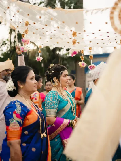 The bride's grand entrance under the phoolon ki chadar, looking absolutely regal in her traditional attire.