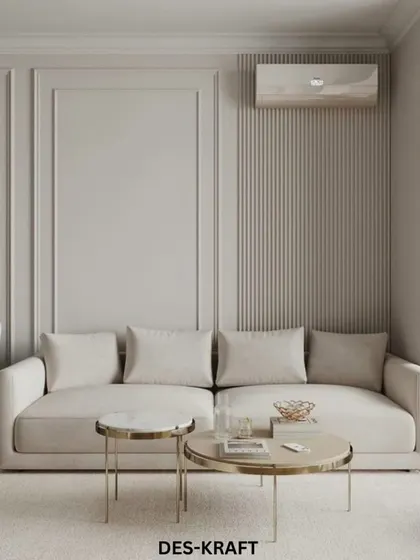 A comfortable sofa in a neutral tone is complemented by gold-accented coffee tables and fluted wall details, demonstrating our approach to creating understated luxury.