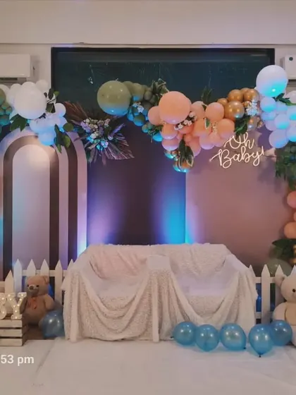 A lovely boho-themed setup with a white picket fence. The earthy tones of the balloon arch, combined with an 'Oh Baby' sign and teddy bears, create a warm and rustic feel.