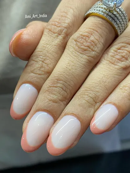 A close-up of the peach French tips, highlighting the flawless application and glossy finish.