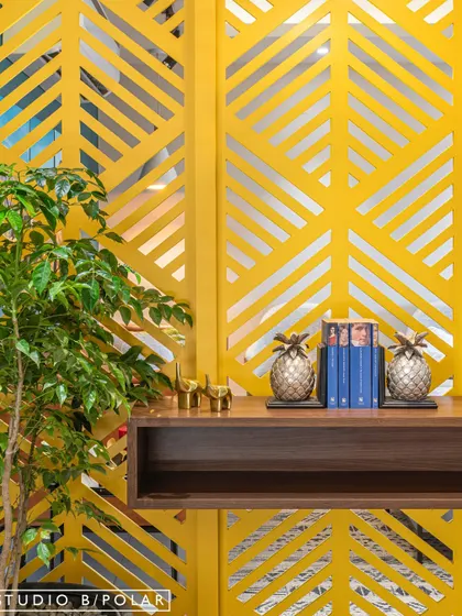 A detail from an early project where we fully embraced color. A bright yellow laser-cut partition with a leaf motif serves as a functional art piece, separating spaces while adding a joyful, graphic element.