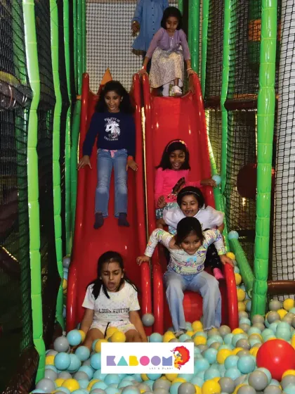 A whole group of friends sliding into the ball pit at once! It's moments like these that create the best birthday memories.