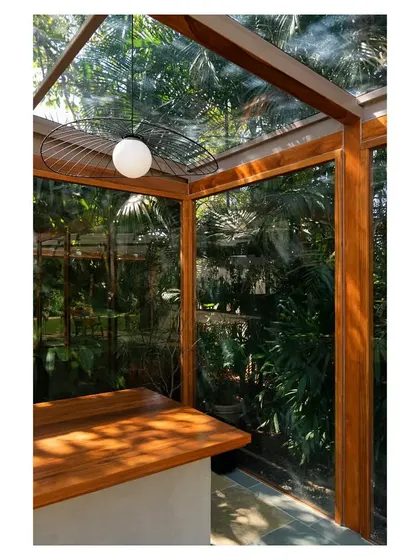 A close-up of the bar counter, where the surrounding garden is visible through the glass walls, making you feel like you are outdoors.