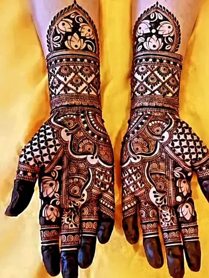 This is a classic example of Rajasthani bridal mehndi, with extremely fine lines, check patterns, and lotus motifs. The dark, filled fingertips complete the traditional look.
