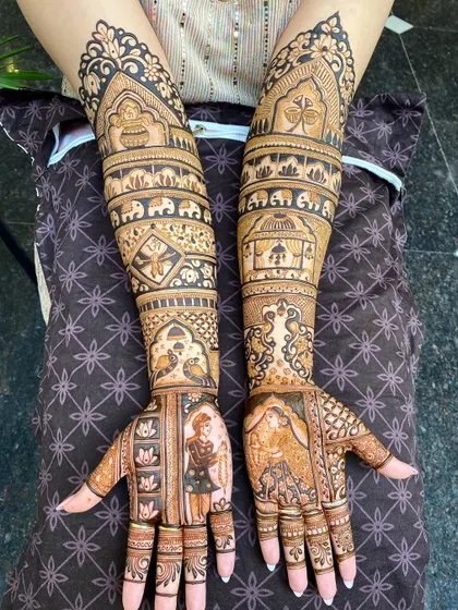 A stunning full-arm bridal design featuring portraits of the bride and groom. The artwork is filled with traditional Rajasthani elements, creating a rich and meaningful design.