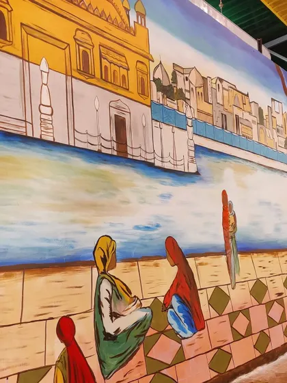 A close-up on the figures sitting by the water in the Golden Temple mural. Adding these human elements helps to bring the scene to life and tell a story.