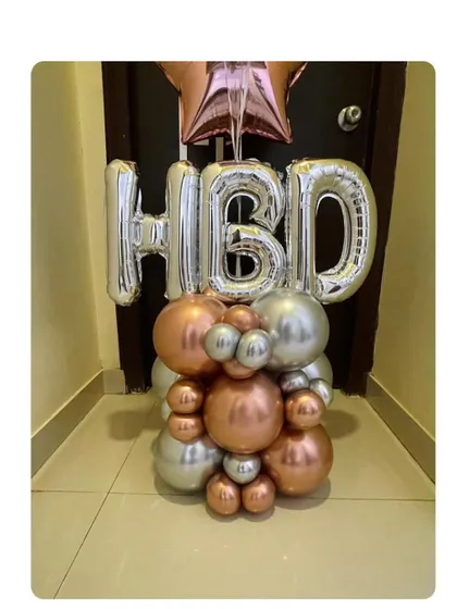 Balloon bouquets never go out of style. This compact standing arrangement with 'HBD' foil letters in silver and a rose gold and silver base is perfect for smaller spaces.