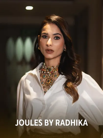 A close-up of Aneri Vajani, showcasing the intricate details of the Navratna-style choker that adds a pop of color and luxury to her look.