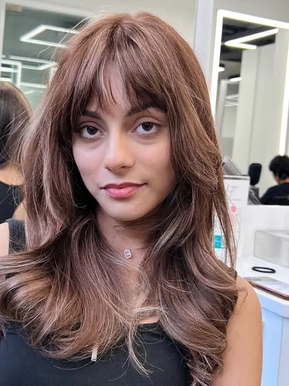 A beautiful, warm brown color with a fresh, layered haircut. The right style can make a client's smile shine.