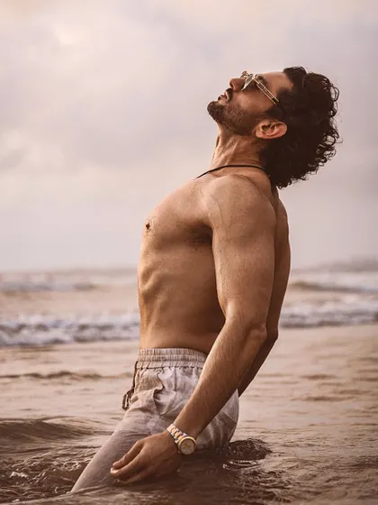 A powerful pose by Shaad Randhawa against the ocean backdrop, capturing a moment of raw energy.