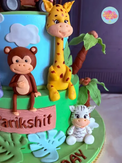 More details from the jungle safari cake, showcasing the friendly giraffe, monkey, and zebra figures.