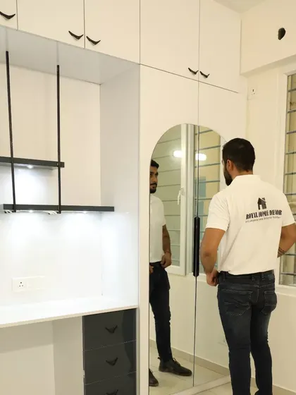 This unit combines a study desk with a full-height wardrobe that has an integrated mirror. The hanging lights above the desk add a stylish and functional touch.