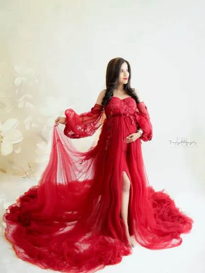 A bold and beautiful statement. This mama-to-be looks powerful and radiant in a striking red gown with a thigh-high slit and flowing fabric.