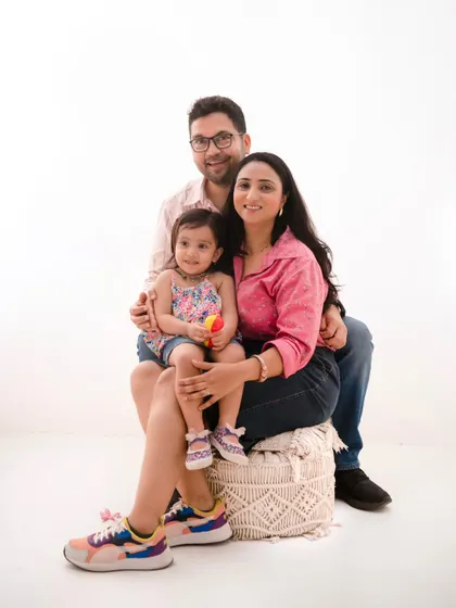 A relaxed and happy family portrait. Dressed in casual, colorful attire, this family's comfortable interaction is the highlight of this shot against a minimalist white background.
