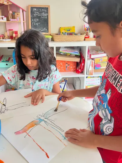 Two friends collaborating on a beautiful watercolor dragonfly painting. Our personalized classes allow children to explore specific interests and techniques.