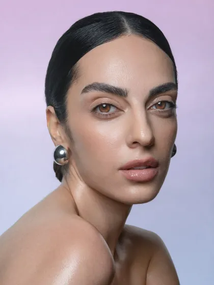 A direct and engaging portrait. The focus is entirely on the model's face, with makeup used to enhance her natural beauty.