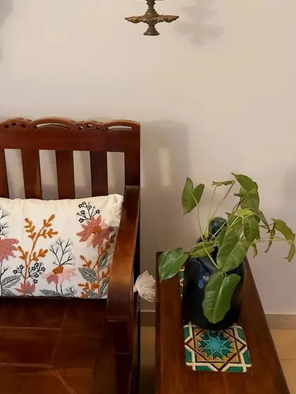 A cozy corner featuring a wooden bench and a custom side table with a single inlaid tile. This shows how even small details can add immense character and a sense of story to a space.