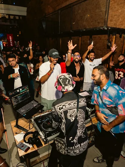 A wide shot showing the crowd gathered around the DJ booth. I love it when the party gets up close and personal.