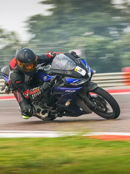A rider on a Yamaha R15 V3 leans into the famous parabola at Buddh International Circuit, proving you don't need a liter-class bike to master the track.