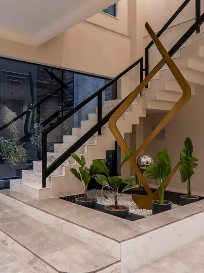 A modern staircase becomes a sculptural element with an integrated planter at its base. This design detail brings a touch of nature indoors and transforms a functional element into a piece of art.
