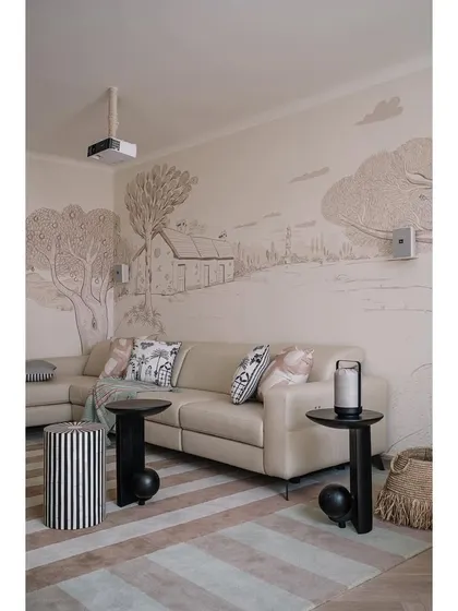 The den and media lounge at Eden House features a full wall hand-painted mural, bringing a sense of the countryside into this urban home.