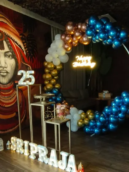 This birthday setup at a restaurant features a striking combination of metallic blue, gold, and white balloons. The marquee letters for the name and age add a personal touch that makes the guest of honor feel extra special.