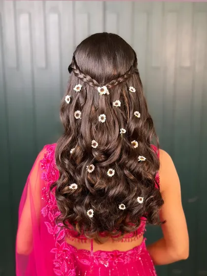 A back view of this beautiful floral mehendi hairstyle. The small, daisy-like flowers add a touch of freshness and fun, perfect for a daytime celebration.