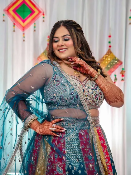 This bride is twirling with joy at her Samurta ceremony. Her makeup features a soft glam eye and a flawless base that enhances her natural beauty, letting her colorful outfit shine.