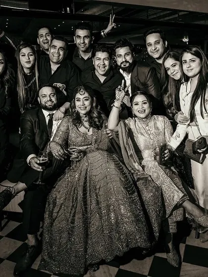 A classic black and white group photo of the couple with their friends at the cocktail party. A perfect memory of the people who celebrated with them.