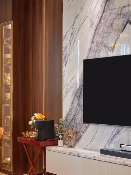 This open-concept dining area features an exquisite Italian marble TV wall as its focal point. A sleek crockery unit adds a touch of luxury, while large windows make the space feel bright and airy.