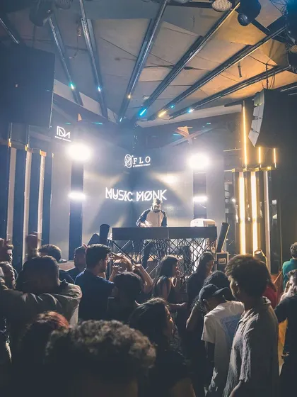 A wide shot of the club with me at the center, commanding the room. The lighting and stage setup create an immersive atmosphere.