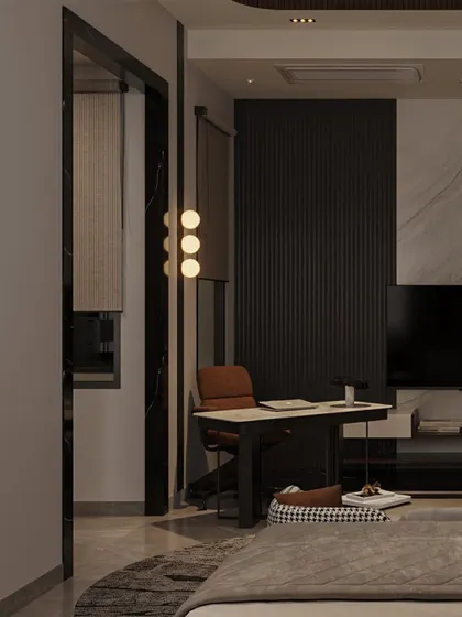 A small, functional workspace is carved out in the corner of the bedroom, featuring a minimalist desk and a modern pendant light. The dark, fluted wall panel adds texture and depth.