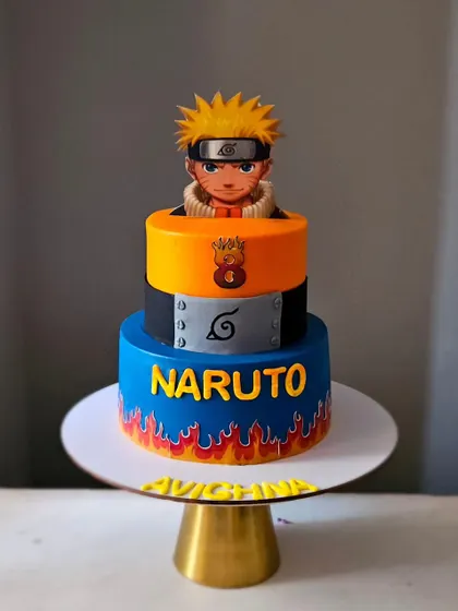 A fiery Naruto theme cake made with colored ganache. This two-tier cake features the iconic character and flame details for an action-packed birthday.