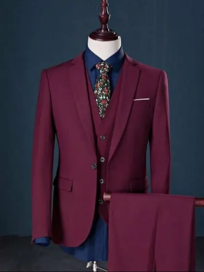 A rich maroon three-piece suit, perfect for a wedding reception or a formal party. The color is deep and the tailoring is sharp.