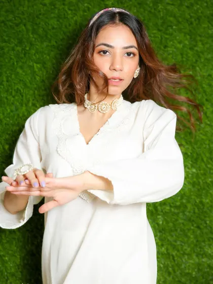 A dynamic shot with movement, capturing the flow of the model's hair and the light fabric of her white kurta.