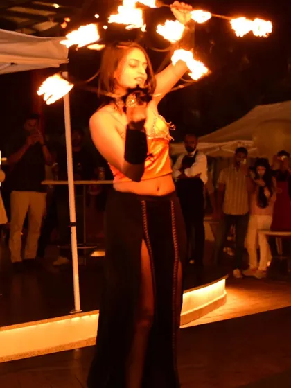 A high-energy moment from an Oktoberfest fire show. The combination of fire snakes and a dynamic pose captures the excitement of the event.