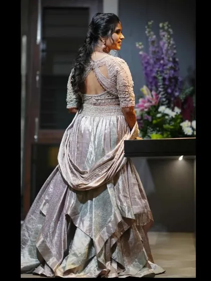 This client is a vision in her modern draped saree gown. The corset-style blouse with intricate embroidery and the unique draping of the saree create a look of pure glamour.