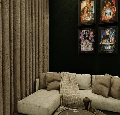 This corner of the multipurpose room is designed as a cozy reading or conversation nook, complete with a comfortable sofa and framed movie posters.