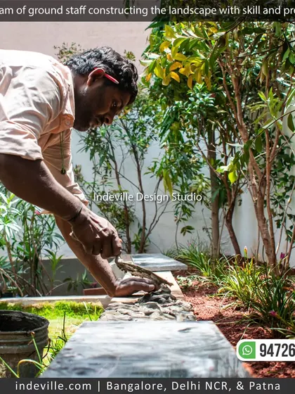 A worker carefully placing stones on a planter edge. This attention to detail is what defines my work.