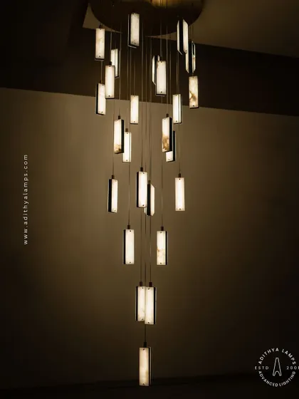 These modern pendants feature a unique combination of translucent marble and stitched leather accents. The warm light glows through the marble, creating a sophisticated and texturally rich fixture for contemporary spaces.