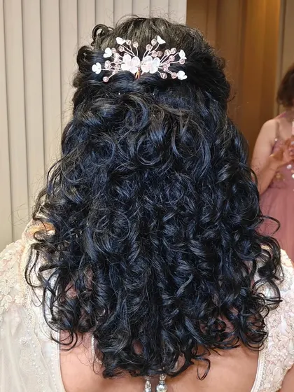A beautiful half-up style for naturally curly hair. I added a delicate, sparkling accessory to complement her reception lehenga.