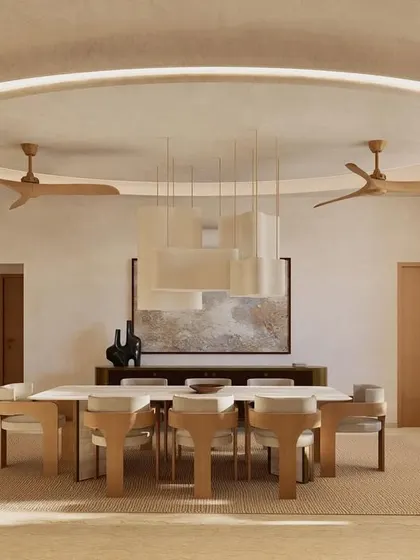 The dining area at Kumo House is a study in refined simplicity. A large table is surrounded by sculptural chairs, all under a statement pendant light, creating a perfect setting for shared meals.