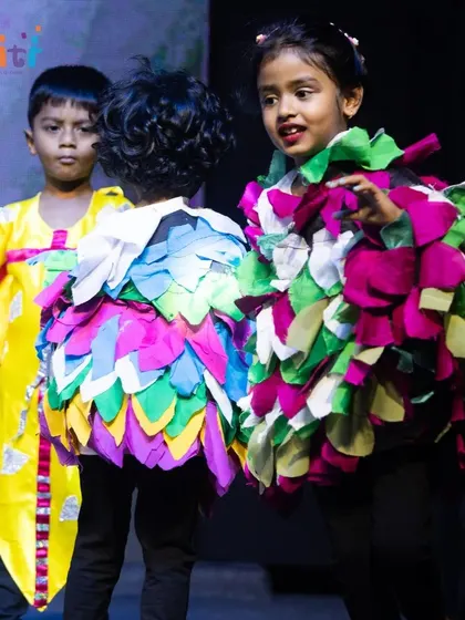 Two children in bird costumes interact on stage, adding a playful element to the dance of Vayu.
