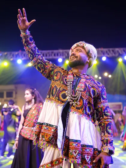 Arms raised, soaking in the energy of the massive crowd at a Navratri night. These are the moments I live for.