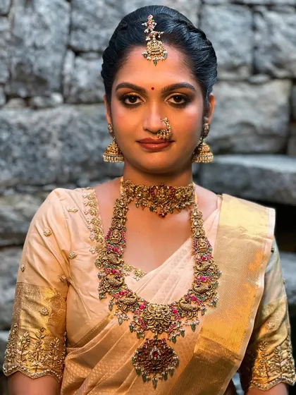 A powerful and direct portrait of a bride in her full wedding attire. The makeup is designed to be bold yet elegant, perfectly framing her features and complementing the grandeur of her Kanchipuram saree.