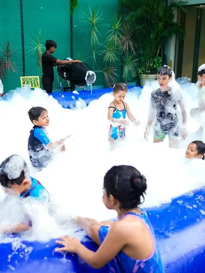Kids completely immersed in the fun of a foam pit. It's a safe and exciting activity that always proves to be a highlight of the party.