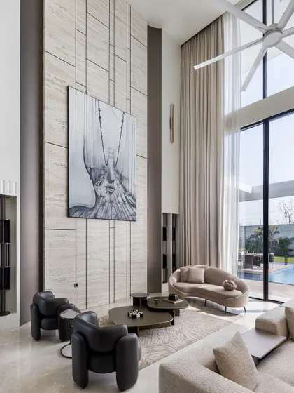 Another view of the light-filled living room, showcasing the impressive architectural volume and seamless connection to the outdoors. The high ceiling and expansive glass create a fresh, natural, and peaceful space.